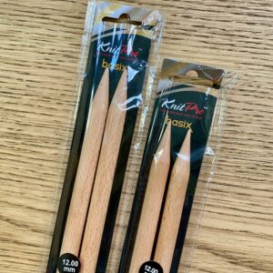 Tips of Basix Birch knitting needles packaged in plastic and black card.